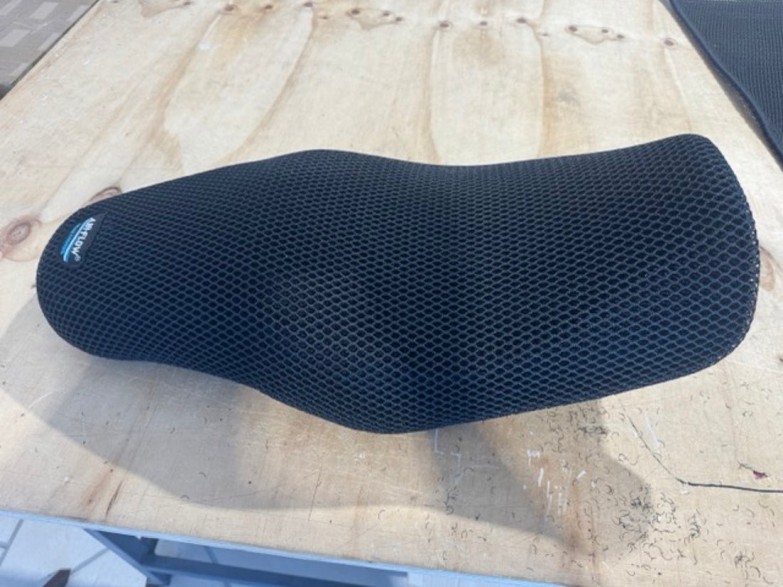 Air-Flow 3D mesh motorcycle seat cover removed and resting on a bench, brand label visible